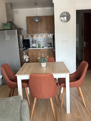 A modern kitchen with a microwave, sink, and wooden cabinets. - The Auryline (Thones)