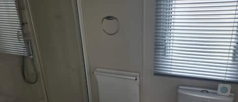 A bathroom with a shower, toilet, and sink.