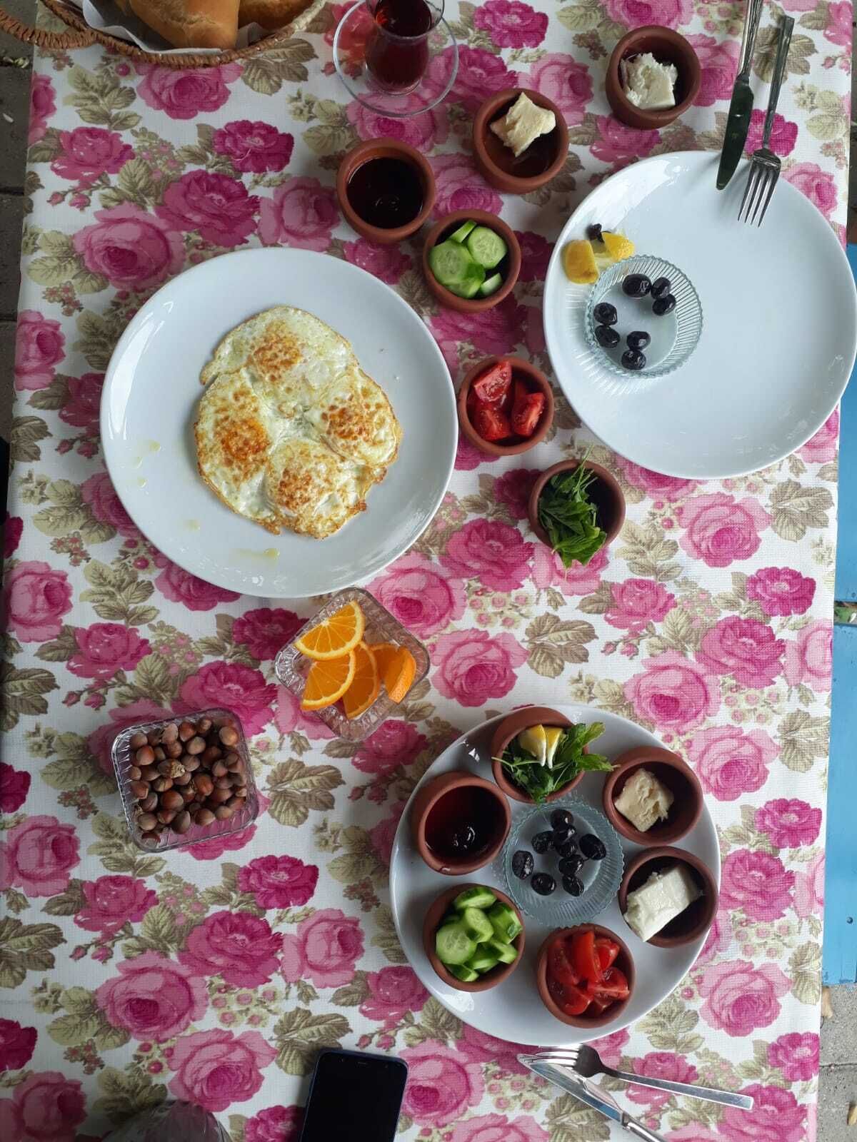 A table with a floral tablecloth, various food items, and a plate with an omelette.