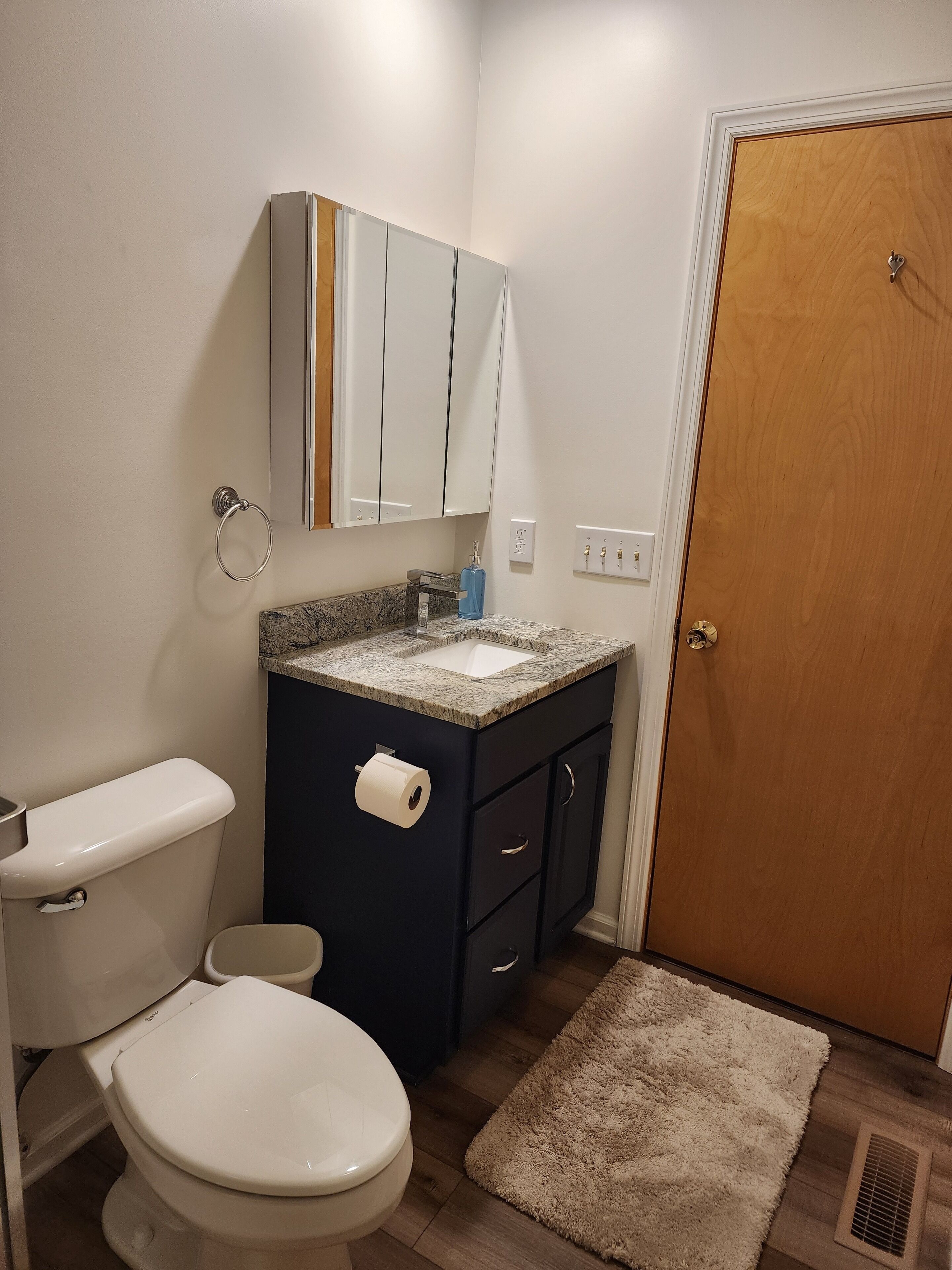Ein Badezimmer mit Toilette, Waschbecken, Spiegel und Tür.