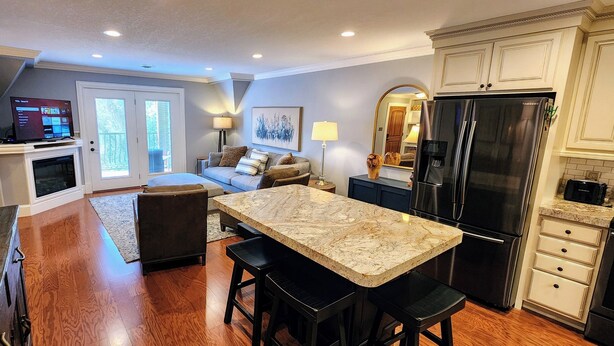 A modern kitchen with a large island, built-in appliances, and a cozy seating area with a sofa and chairs. - The Loft at the Old Mill-Cozy 2-bedroom Loft in charming Pigeon Forge! (Pigeon Forge)