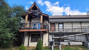 A two-story building with a balcony and a staircase. - The Loft at the Old Mill-Cozy 2-bedroom Loft in charming Pigeon Forge! (Pigeon Forge)