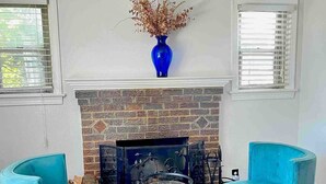 A room with a fireplace, two blue armchairs, and a blue vase with dried flowers on the mantel. - Charming 3-bedroom house by Capitol Hill DC (Washington)