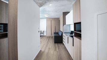 Une cuisine moderne avec des meubles en bois, un four à micro-ondes encastré et un téléviseur à écran plat.