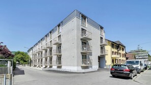 A multi-story residential building with balconies, a parking area, and a clear sky. - Mooi Apartments Biel (Biel)