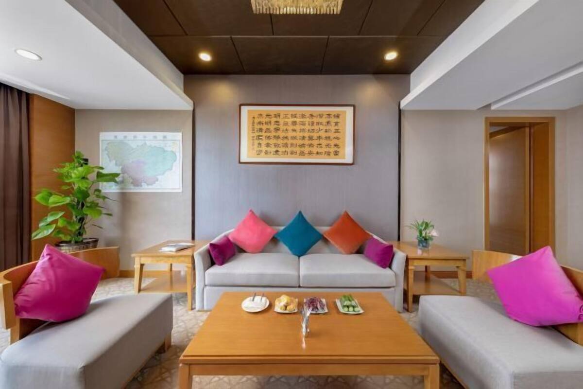 Una habitación de hotel moderna con un conjunto de sofás, una mesa de centro y un mapa en la pared.