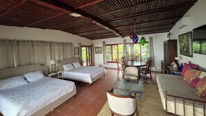 A room with two beds, a dining table, and a sofa. - B&B Casa Naturaleza Playa Corona (Las Uvas)