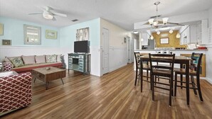 Un salon spacieux comprenant un canapé, une table basse et un coin repas avec des chaises.