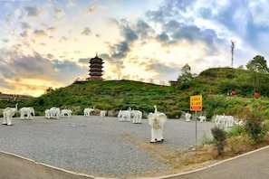 A pagoda on a hill with a paved area in front. - Jinli Hotel (Qinglong)