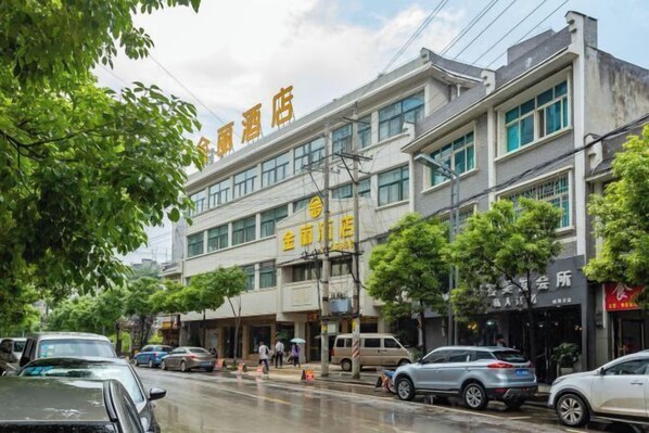 A multi-story hotel with a prominent sign in the center. - Jinli Hotel (Qinglong)
