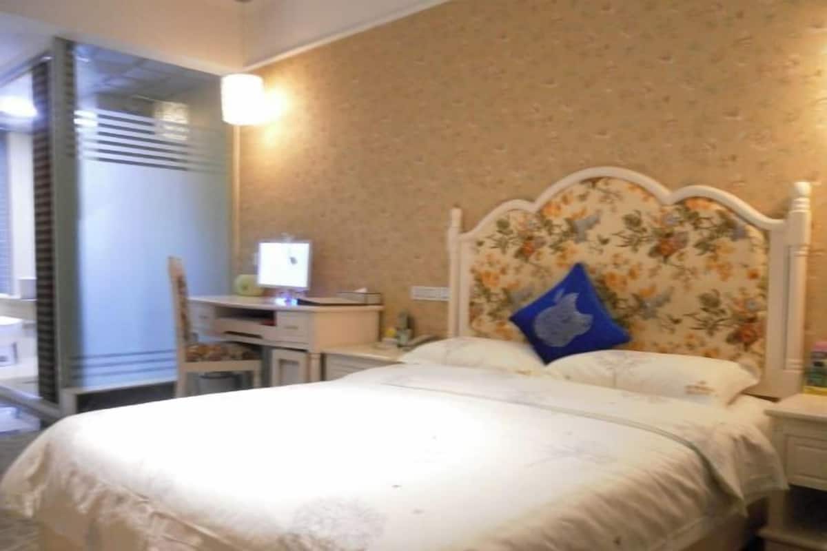 Un dormitorio con cama, escritorio y silla.