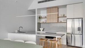 Een moderne keuken met een centraal eiland, roestvrijstalen apparatuur en een minimalistisch design.