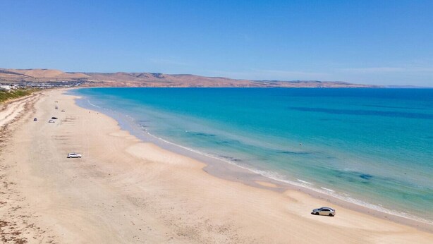 A wide sandy beach with clear blue waters and distant hills. - Casa Billie ~ Family friendly beachside oasis (Aldinga Beach)