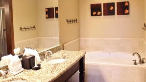 A bathroom with a double sink vanity, a large mirror, and a bathtub. - Grand Lodge Peak 7: True Ski-in Ski-out resort Jan 10-17,2026  Breckenridge, CO  (Breckenridge)