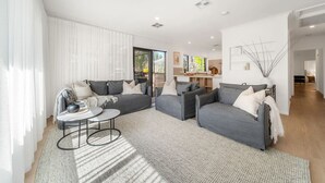 A modern living room with grey sofas, a coffee table, and a large window. - The Grape Escape~ Location & style on Shiraz Trail (McLaren Vale)