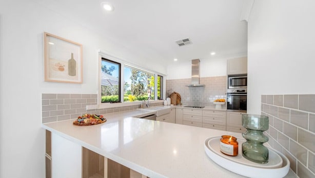 A modern kitchen with a large island, white cabinetry, and a view of the outdoors. - The Grape Escape~ Location & style on Shiraz Trail (McLaren Vale)