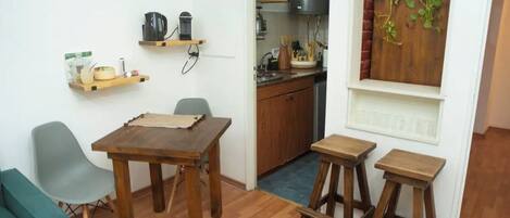 A compact kitchen with wooden cabinets, a built-in stove, and a small window with a brick wall.