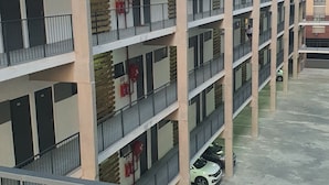 Un aparcamiento de varios pisos con múltiples niveles, extintores y algunos coches estacionados.