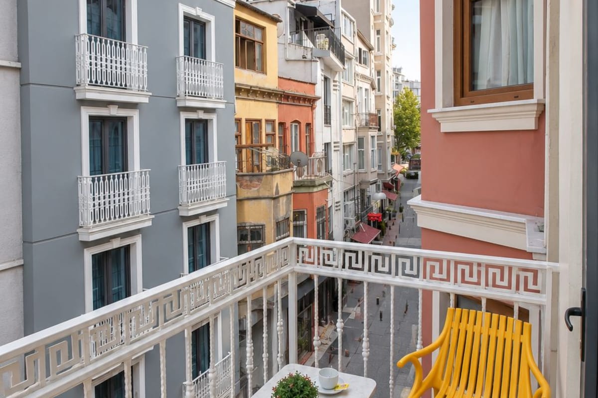 A balcony with a table, two chairs, and a potted plant.