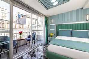 A hotel room with a large window, a balcony with chairs, a bed with green bedding, and a nightstand with a lamp. - Santa Rio Gold Taxim (Istanbul)