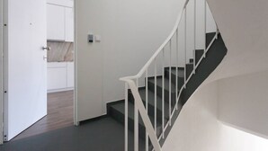 Een trap met witte leuningen die uitkomt op een plateau.