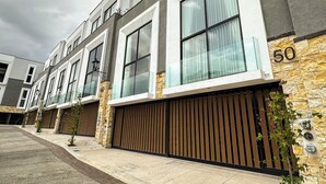 A modern multi-story residential building with large windows and a stone facade.
