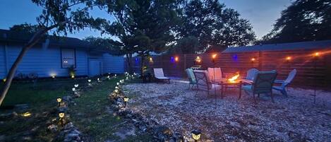 A backyard with a fire pit and outdoor seating.