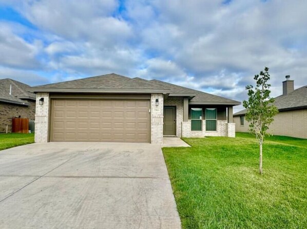 Stunning home with a brick facade, flat roof, and a charming front yard.