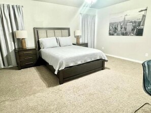 Relax in this serene bedroom with a large bed, two nightstands, and a city view.