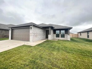 Stroll up to the covered porch and enter through the glass entrance to this single-story home.