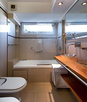 A compact, modern bathroom with a bathtub, toilet, and sink. - 2BR with Spectacular City Views & Sunset Magic! (Buenos Aires)