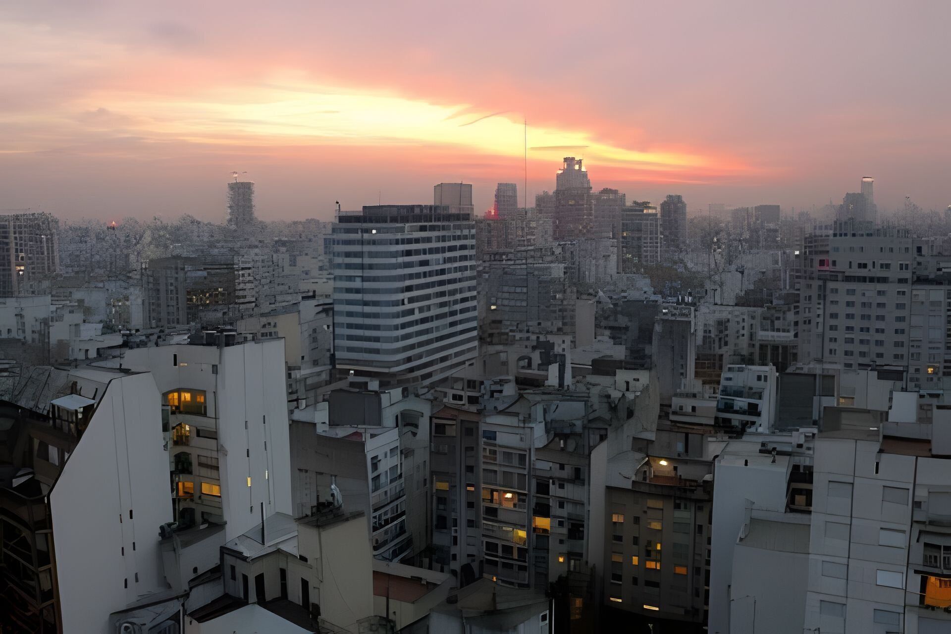 Un paysage urbain caractérisé par une diversité de hauteurs et de styles architecturaux, comprenant un imposant gratte-ciel moderne et plusieurs bâtiments de taille moyenne.