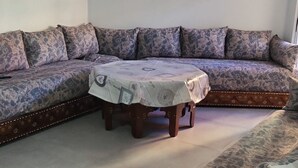 A living room with a sectional sofa, a round coffee table, and a patterned rug. - Sunny Gandia Apartment With 2 Bedrooms (Gandia)