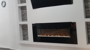 A modern living room with a flat-screen TV mounted above a fireplace. - Sunny Gandia Apartment With 2 Bedrooms (Gandia)
