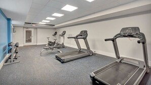 Ein Fitnessstudio mit Laufbändern, Crosstrainern und Krafttrainingsgeräten.