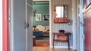 A hallway with a wooden bench, a small table, and a mirror on the wall.