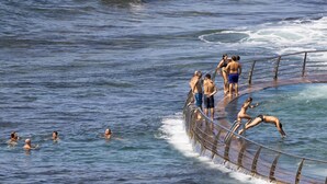 A swimming pool with a wooden deck and metal railings, surrounded by calm water. - Home2Book Luminous Seaviews Apt Near The Ocean (Punta del Hidalgo)