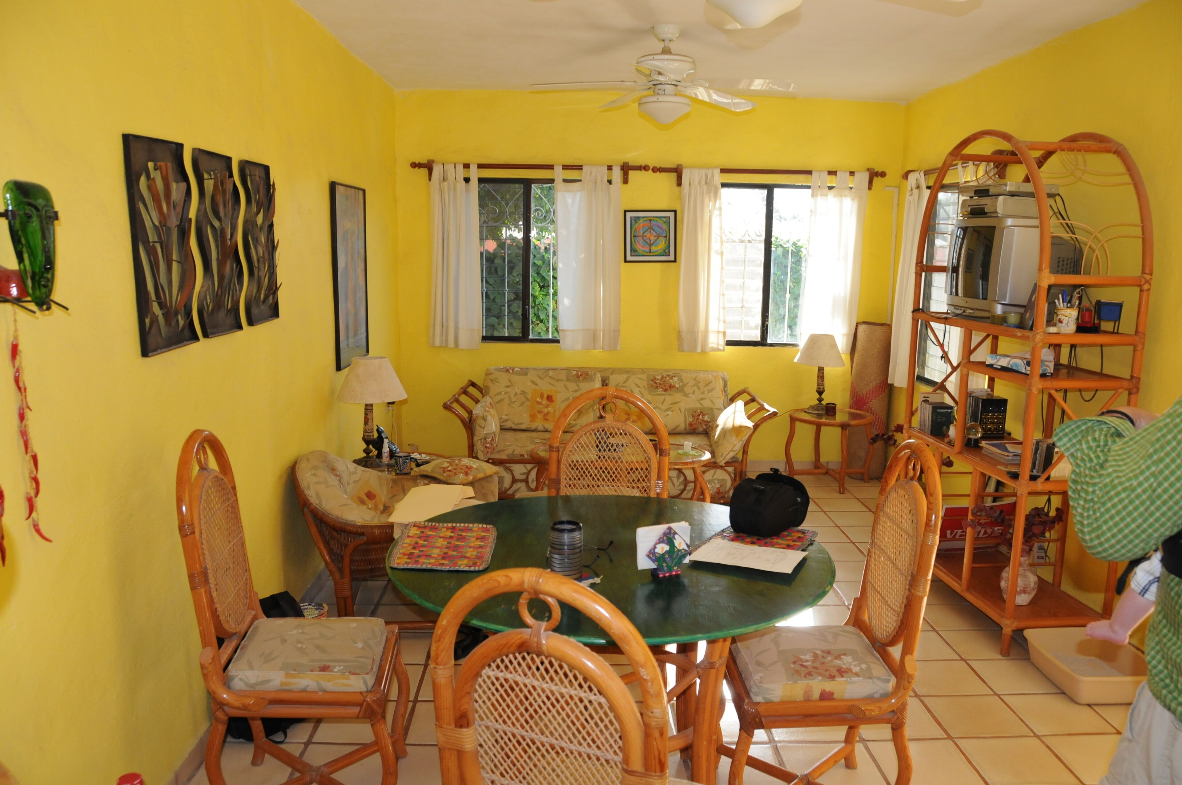 A dining area with a round table, chairs, and a ceiling fan.