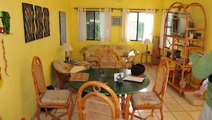 A dining area with a round table, chairs, and a ceiling fan.