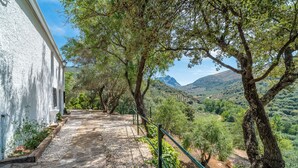 Un sendero de piedra que conduce a un edificio blanco con vistas a un paisaje montañoso.