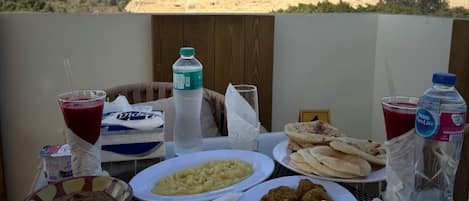 A table with various food items and drinks, set against a backdrop of pyramids.