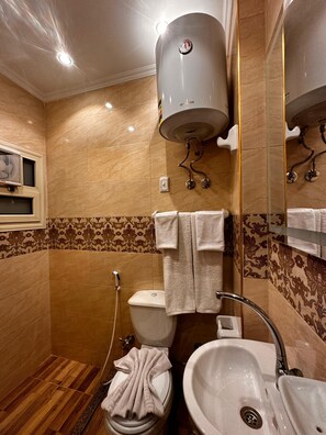 Un baño con inodoro, lavamanos y ducha.