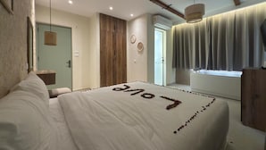 Ein Schlafzimmer mit einem Bett, einem Holzschrank, einem Fenster mit Vorhängen und einer Wand-Klimaanlage.