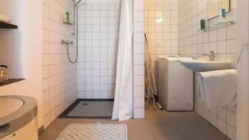 Ein kleines Badezimmer mit Dusche, Toilette und Waschbecken.