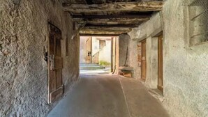 A narrow corridor with stone walls and wooden beams, leading to a staircase. - CASA  VISTA (Lugano)