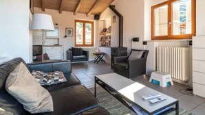 A cozy living room with a sofa, armchairs, a coffee table, and a fireplace. - CASA  VISTA (Lugano)