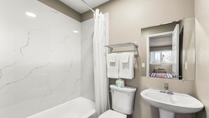 A bathroom with a bathtub, toilet, and sink. - Southern Suites Forest Park (Forest Park)