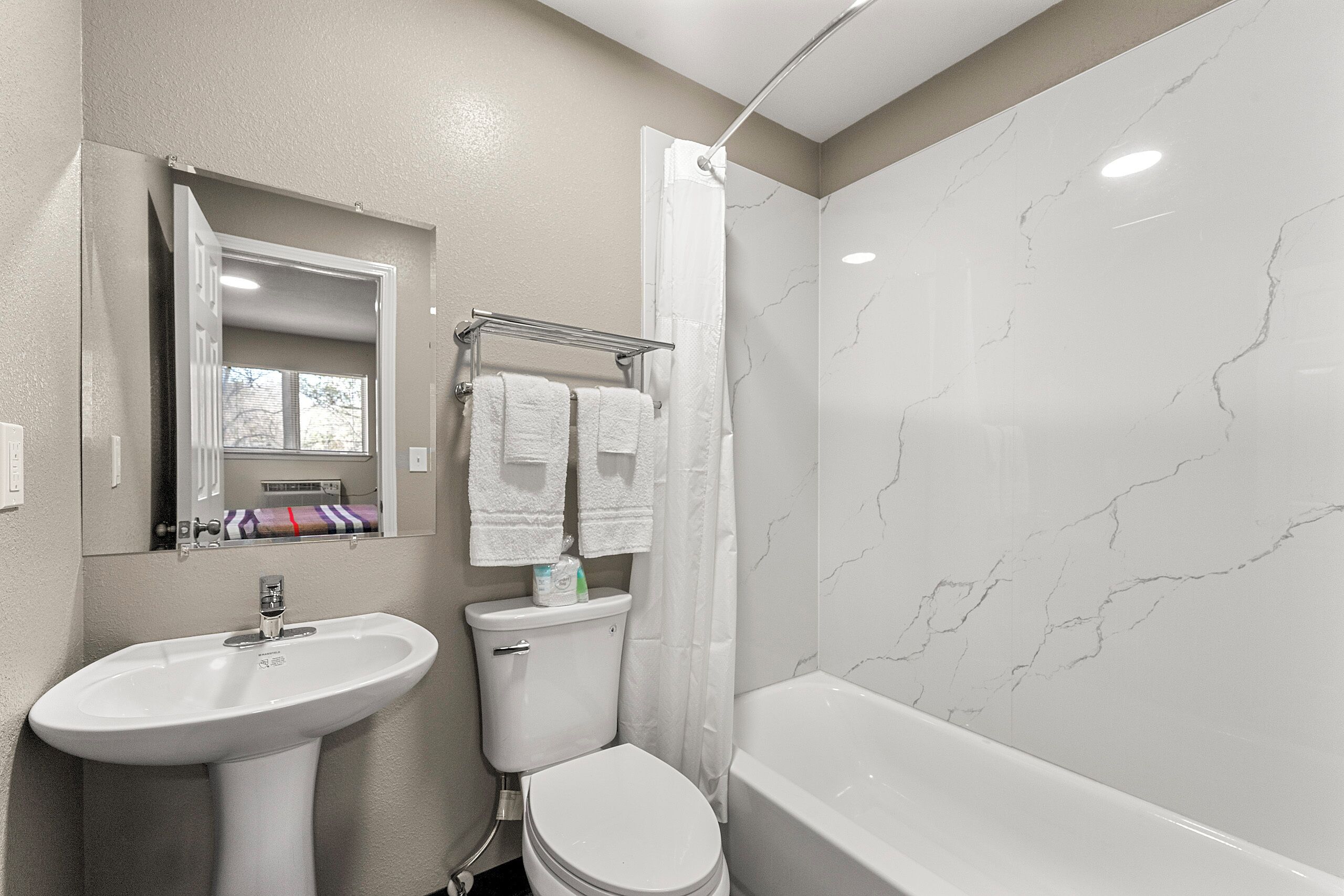A bathroom with a sink, toilet, and bathtub.