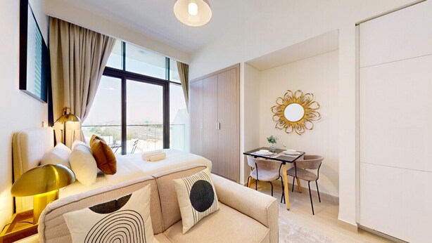 Une chambre d’hôtel moderne équipée d’un canapé, d’une table à manger et d’une grande fenêtre donnant sur un paysage agréable.
