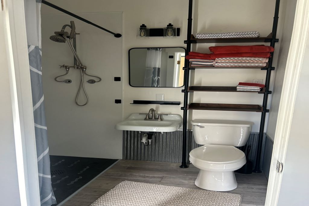 Een douche, handdoeken, zeep, toiletpapier